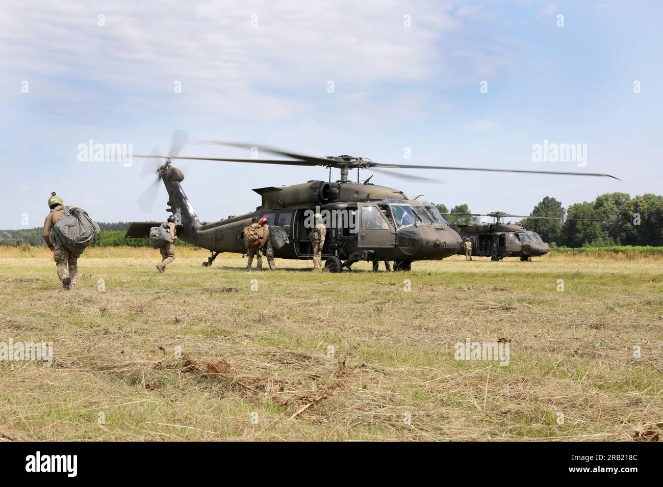 USA Armee-Fallschirmjäger besteigen UH-60 Helicopters als Task Force Nighthawk, 3. Combat Aviation Brigade, 4. Infanterie Division, bietet Flugunterstützung während des Flugtrainings auf einem Flugplatz in Daugavpils, Lettland, Juni 28. Die Mission der 4. Infanterie-Division in Europa besteht darin, sich an multinationalen Schulungen und Übungen auf dem ganzen Kontinent zu beteiligen und mit NATO-Verbündeten und regionalen Sicherheitspartnern zusammenzuarbeiten, um V Corps, Amerikas vorwärtsgerichtetes Korps in Europa, mit Kampfkräften zu versorgen. (USA Militärfoto von Kapitän Daniel Yarnall) Stockfoto