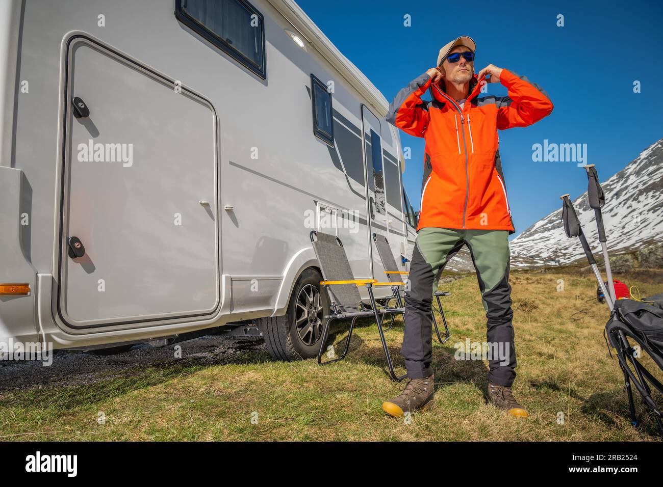 Professionell ausgerüsteter Wohnmobil-Reisender bereitet sich auf eine Bergwanderung vor. Freizeitaktivitäten Im Freien Thema. Stockfoto