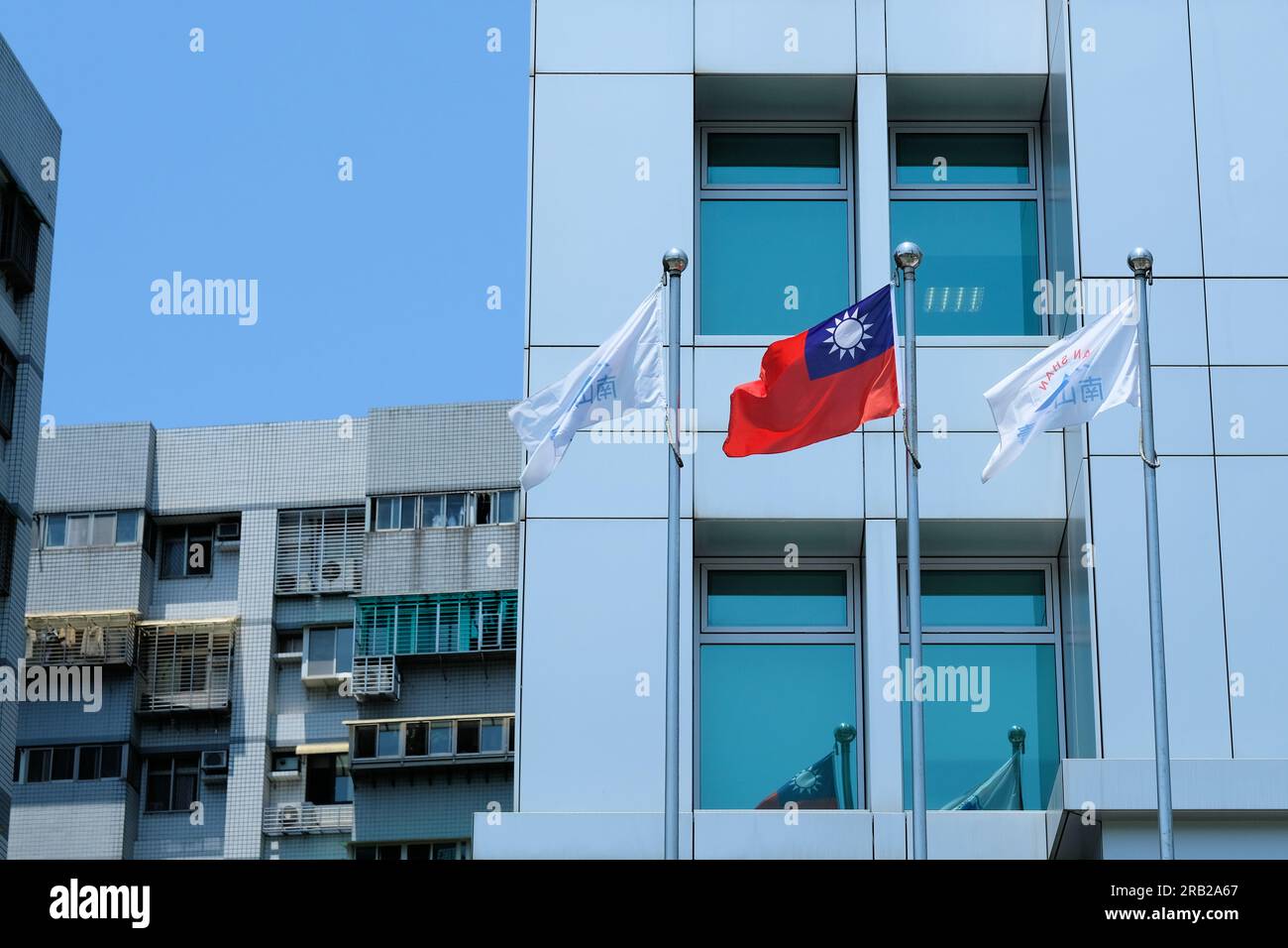 Taiwanesische und Nan Shan-Flaggen vor dem Nan Shan Financial Centre in Taipei, Taiwan; Hauptsitz der Nan Shan Life Insurance Company. Stockfoto