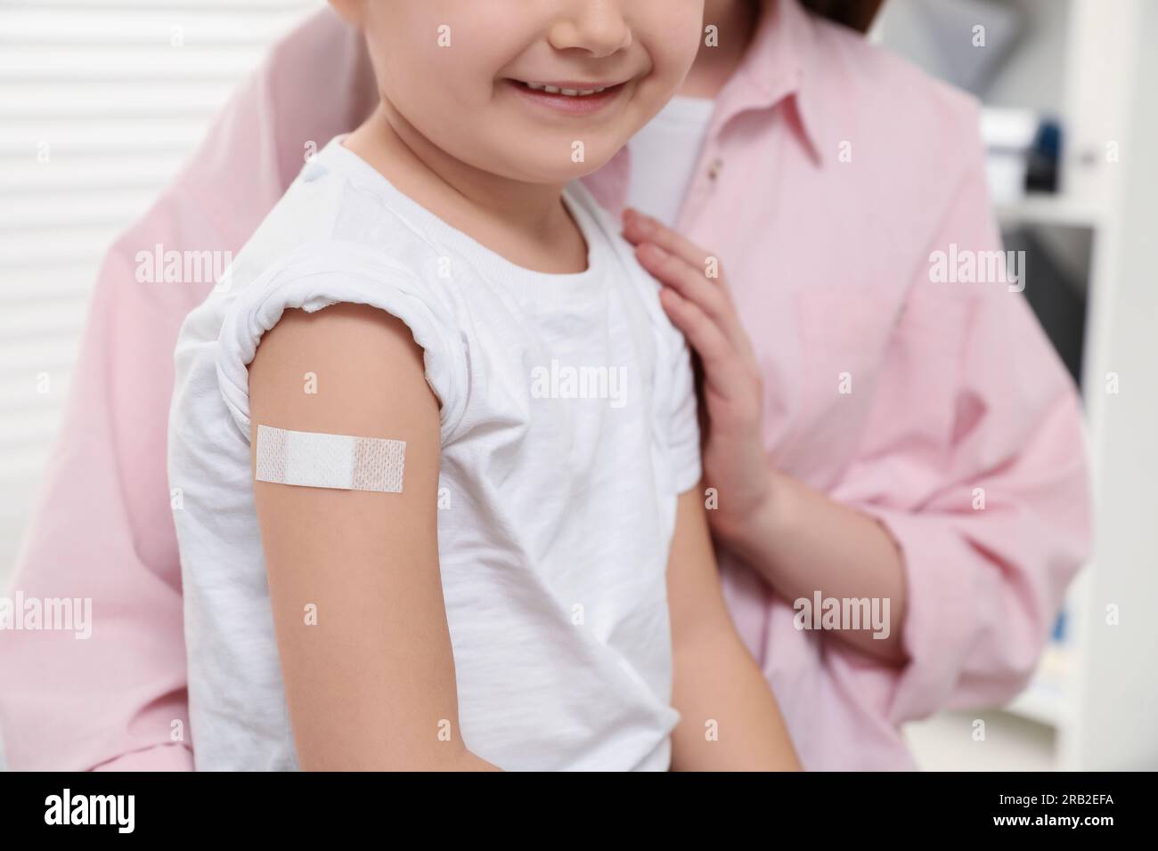 Hepatitis-Schutzimpfung bei Kindern. Mutter und Tochter mit medizinischem Gips in der Klinik, Nahaufnahme Stockfoto