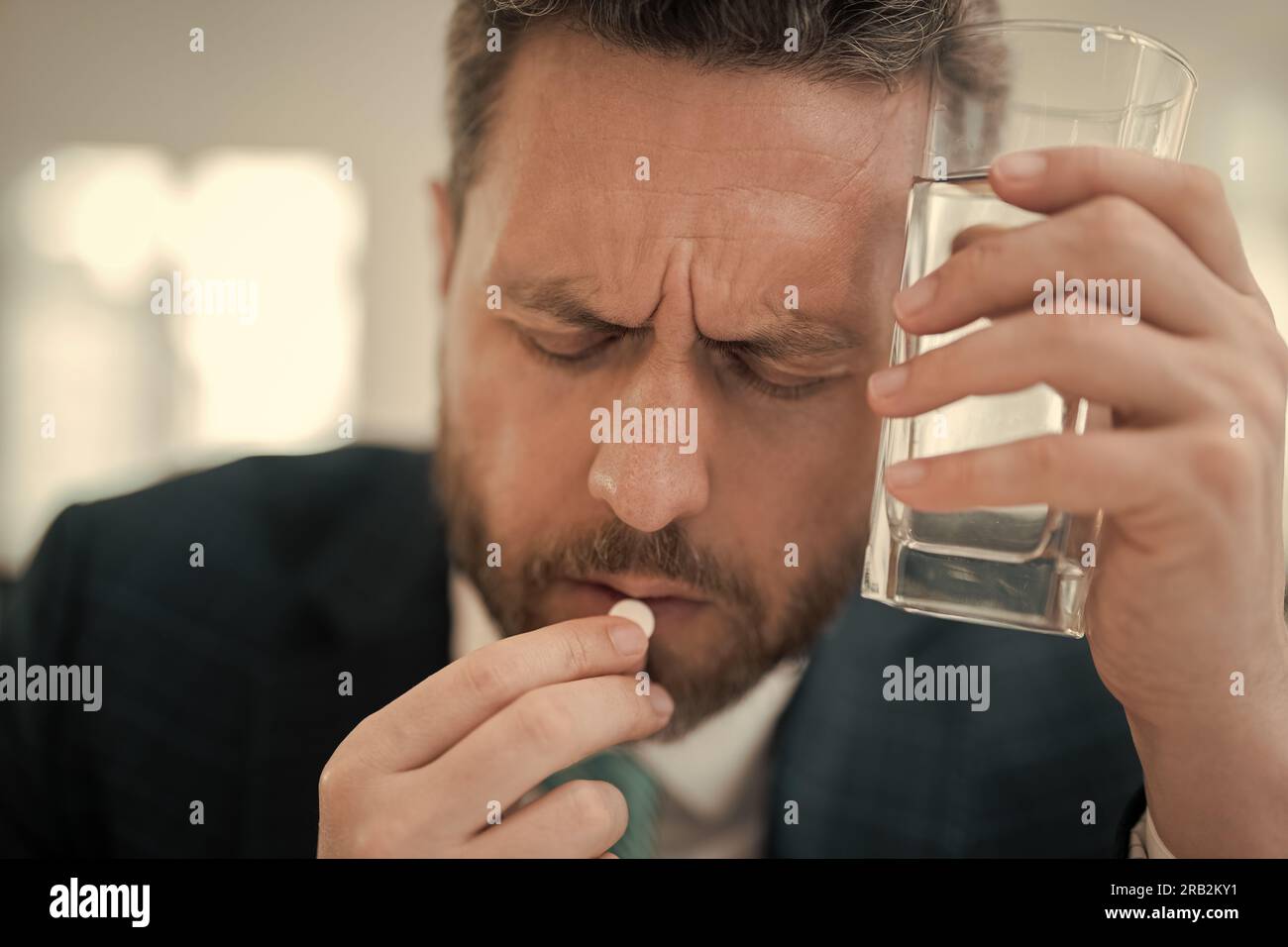 Müder Mann fühlt Schmerzen beim Brillenhalten trockene gereizte Augen ermüdet von Computerarbeit, gestresster Mann leidet an Kopfschmerzen. Mann nimmt Medizin Stockfoto