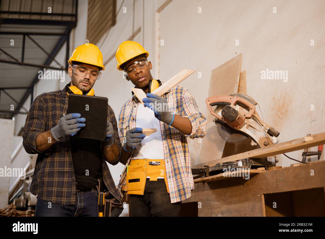 Arbeiterteam, das zusammenarbeitet und über Design Holzarbeiten, moderne Holzmöbel Fabrikarbeiter spricht. Stockfoto