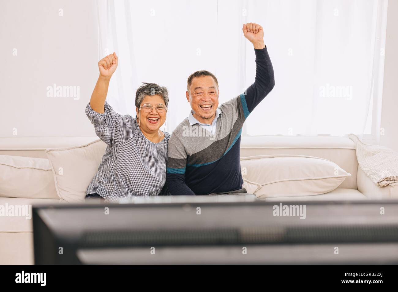 Seniorenfamilie Eldly Asiate Alter Mann und Frau genießen es, zusammen zu Hause im fernsehen Weihnachtsaktivitäten zu sehen Stockfoto