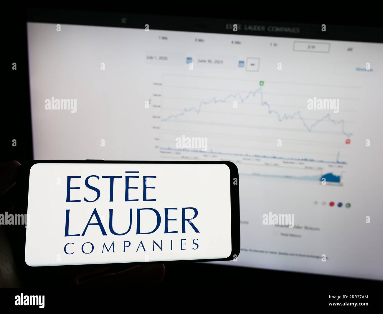 Person, die ein Mobiltelefon mit dem Logo des amerikanischen Unternehmens Estee Lauder Companies Inc. Auf dem Bildschirm vor der Webseite hält. Konzentrieren Sie sich auf das Display des Telefons. Stockfoto