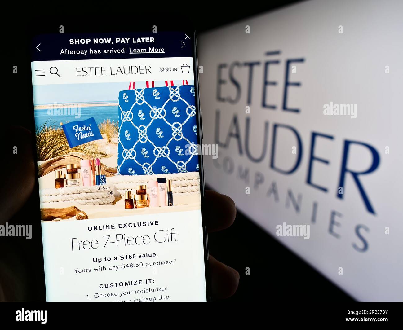 Person, die ein Mobiltelefon mit der Webseite des US-amerikanischen Unternehmens The Estee Lauder Companies Inc. Auf dem Bildschirm vor dem Logo hält. Konzentrieren Sie sich auf die Mitte des Telefondisplays. Stockfoto