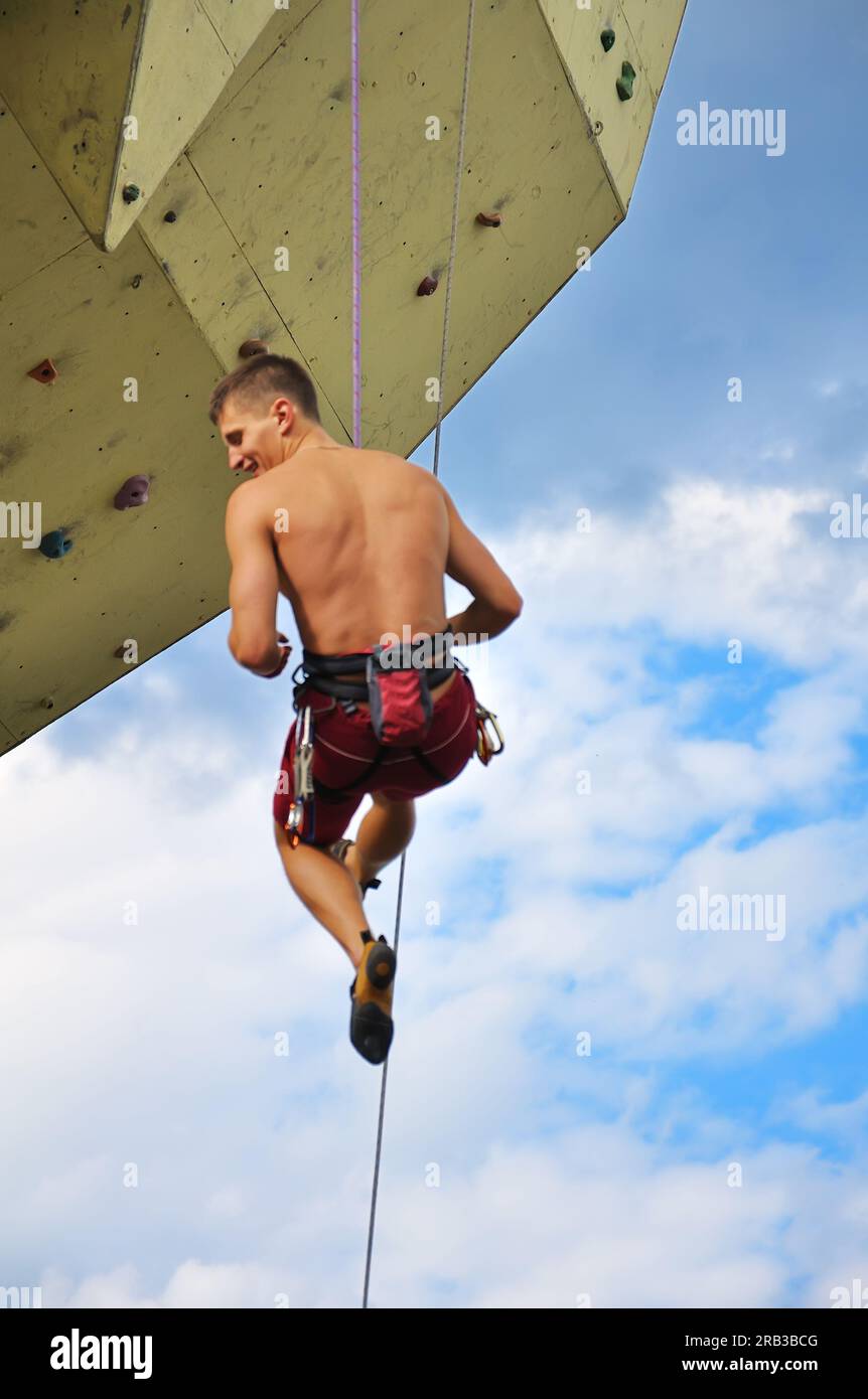 Kletterer hängt am Seil am Himmelshintergrund Stockfoto