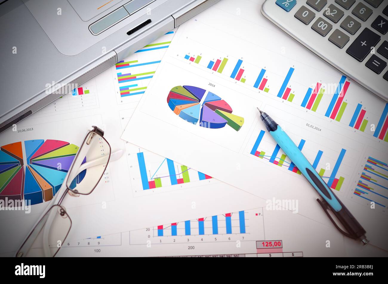 Marktanalysekonzept mit Finanzbericht, Stift, Laptop und Brille Stockfoto