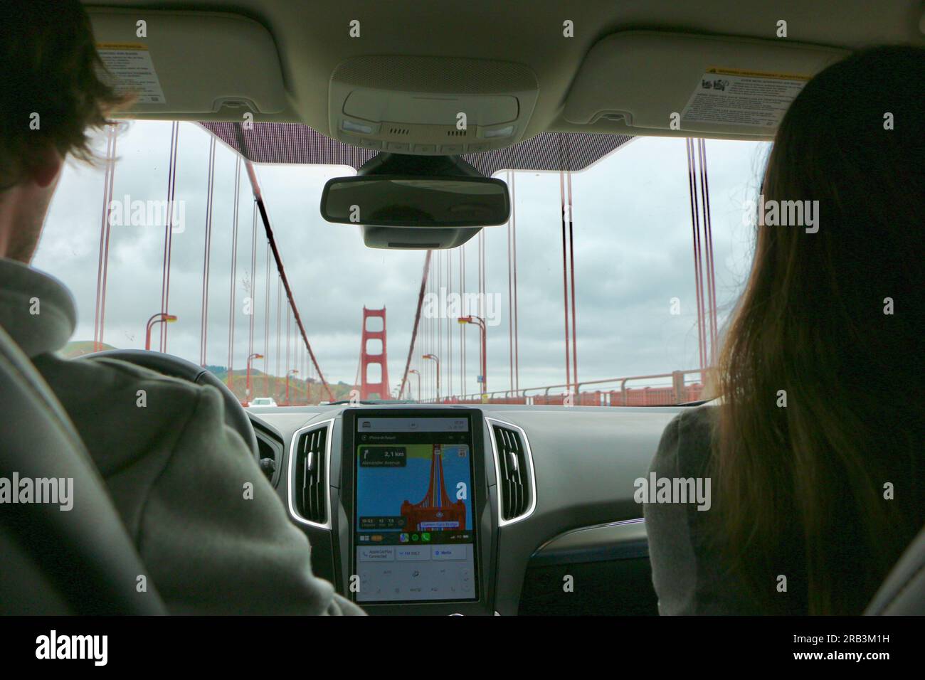 Blick aus dem Inneren eines Autos, das über die Golden Gate Bridge fährt, mit dem SatNav, das die Brücke auf dem Bildschirm zeigt San Francisco California USA Stockfoto