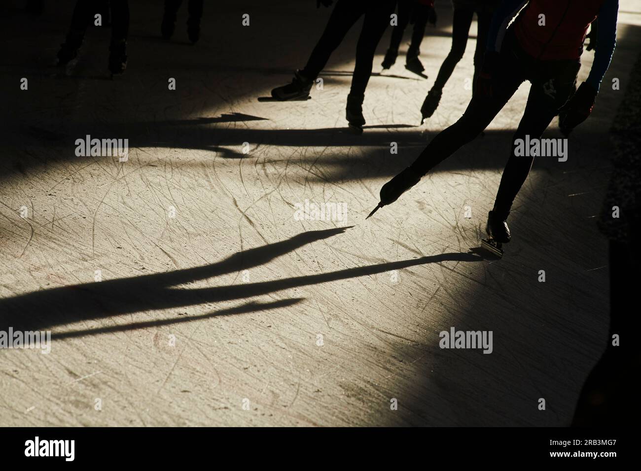 Silhouette von Menschenmassen, die in der hellen Wintersonne Schlittschuhlaufen Stockfoto