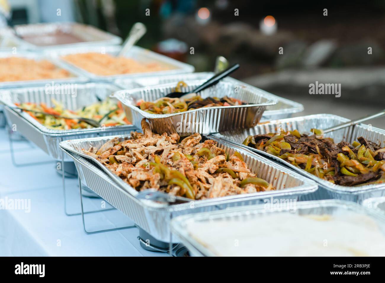 Fajitas und andere mexikanische Speisen werden im Freien auf Aluminiumtabletts serviert Stockfoto