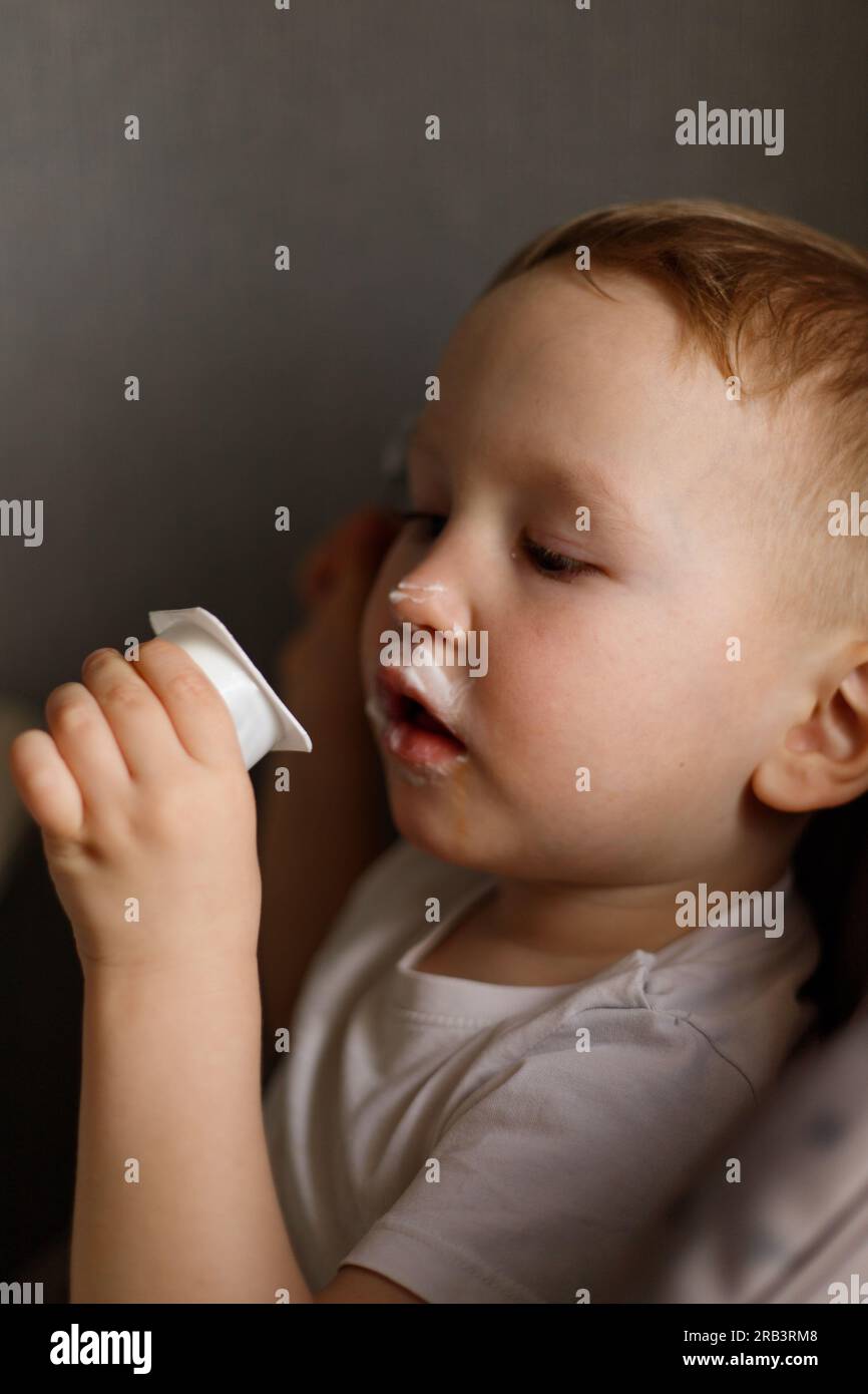 Junge, sieh dir das Joghurtglas an Stockfoto