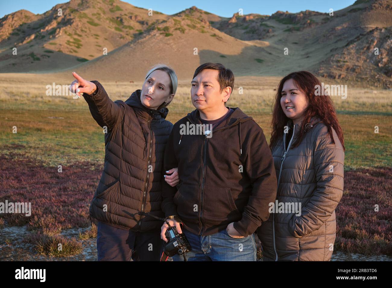 Ein Typ und zwei Frauen, Freunde, die sich Bilder auf dem Kamerabildschirm ansehen Stockfoto