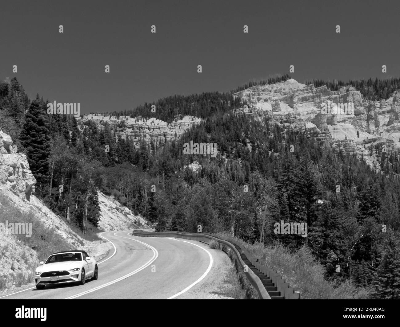 Touristen, die ein Ford Mustang Cabriolet auf dem Highway 14 Utah auf dem Weg nach Cedar fahren, brechen das Nationaldenkmal Stockfoto