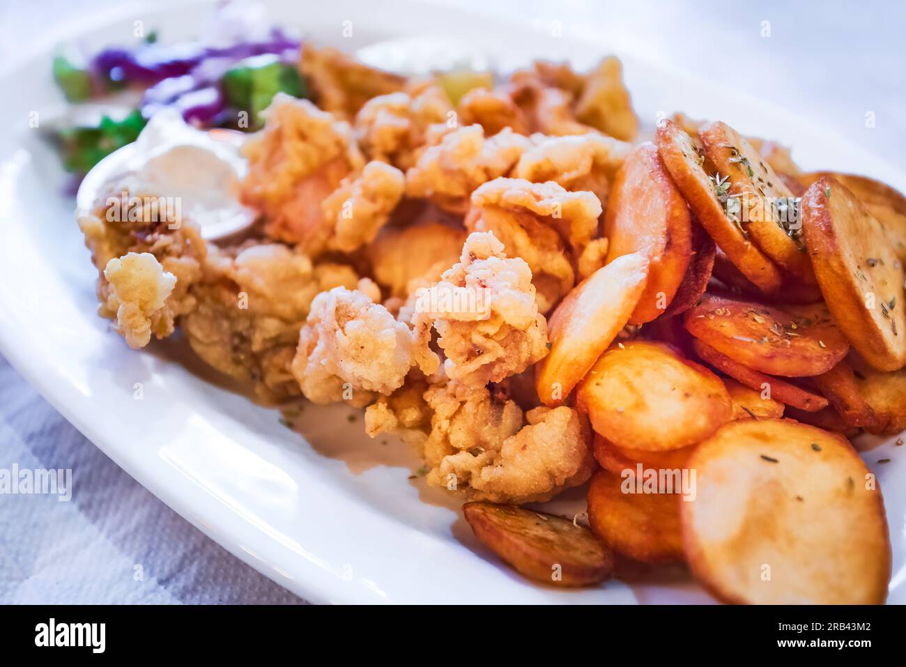 Klassische griechische Taverna mit gebratener Calamari und gebackenen Kartoffeln, Meeresfrüchtekarte auf der Insel Zakynthos, Griechenland. Stockfoto