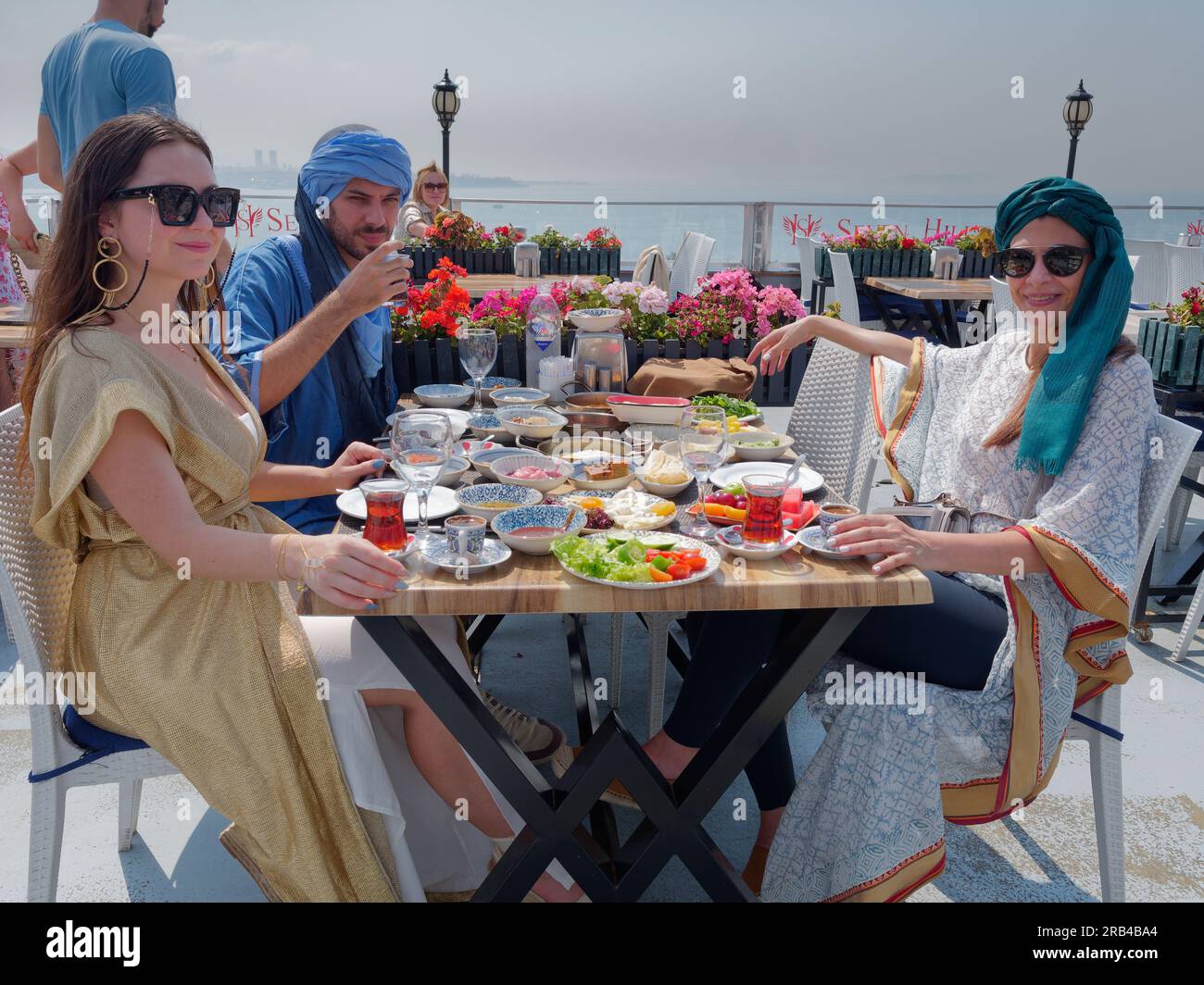 Drei Personen genießen eine Platte mit Speisen zum Frühstück oder Brunch einschließlich türkischem Tee im Seven Hills Restaurant, Istanbul, Türkei Stockfoto