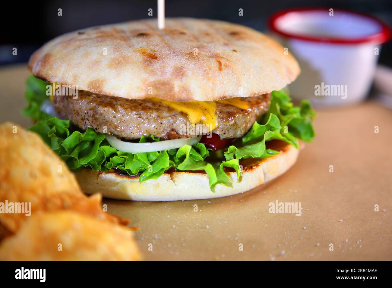 Burger mit Fleisch und Gemüse. Heißer Burger in einer brennenden Sauce. Stockfoto