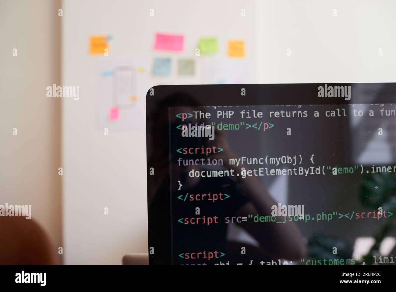 Standzeit des PC-Bildschirms mit demo zur javascript-Codierung, am Schreibtisch im Büro Stockfoto