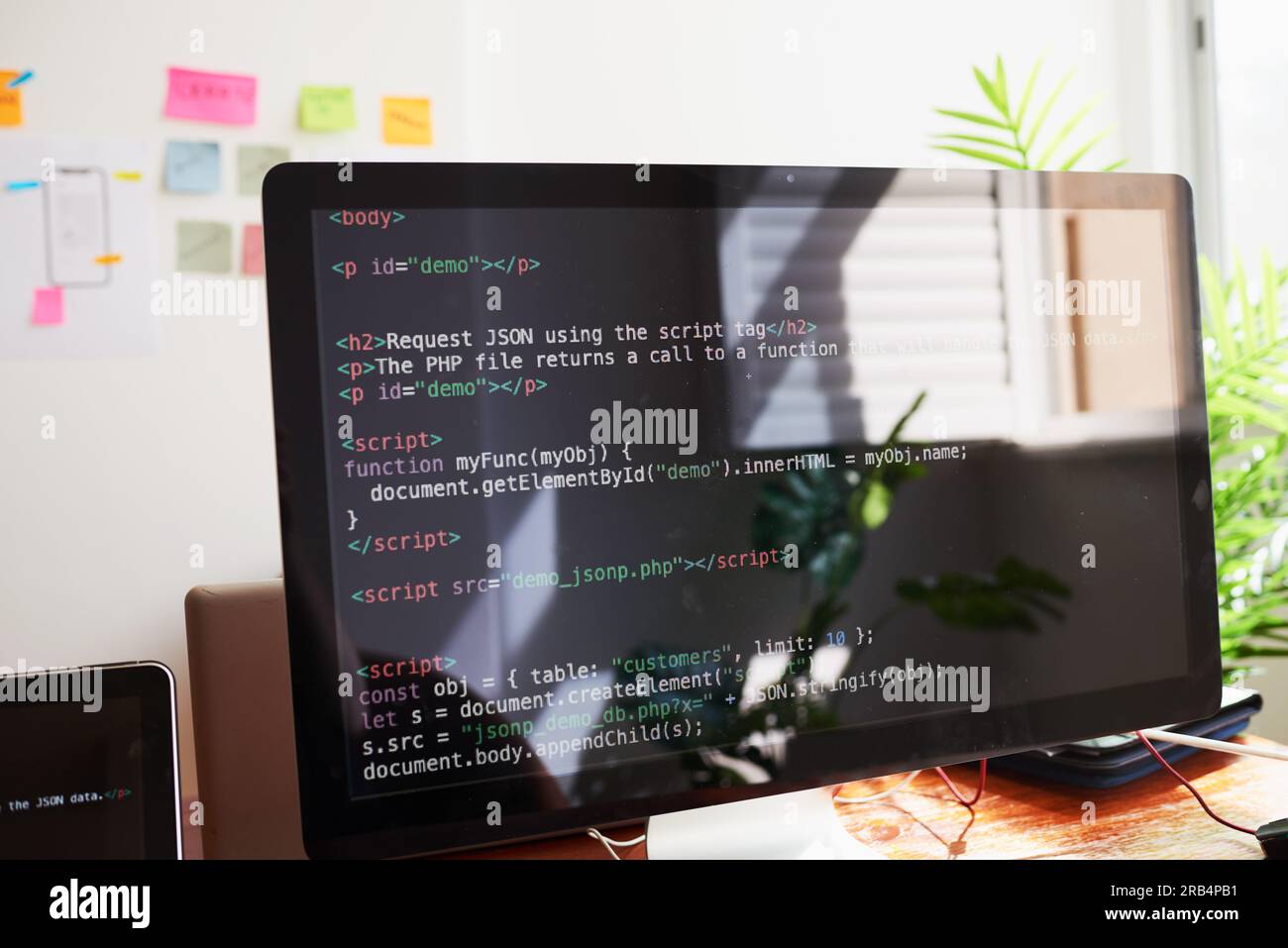 Standzeit des PC-Bildschirms mit demo zur javascript-Codierung, am Schreibtisch im Büro Stockfoto