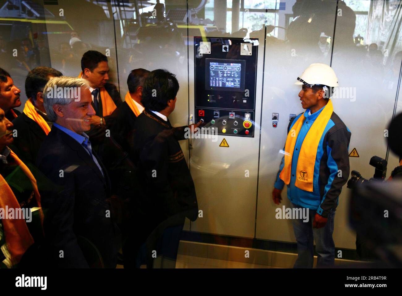 La Paz, Bolivien, 15. September 2014. Der bolivianische Präsident Evo Morales Ayma (Zentrum) schaltet die Motoren ein, um die gelbe Seilbahn während der Einweihungszeremonie offiziell zu eröffnen. Die gelbe Linie ist die zweite von drei Seilbahnlinien, die in diesem Jahr eröffnet werden, und ist Teil eines ehrgeizigen Projekts zur Entlastung des Verkehrsaufkommens. Die erste Linie, die im Mai eröffnet wurde, wird, wenn alle drei geöffnet sind, das längste städtische Seilbahnsystem der Welt sein. Das System wurde von der österreichischen Firma Doppelmayr gebaut. Stockfoto