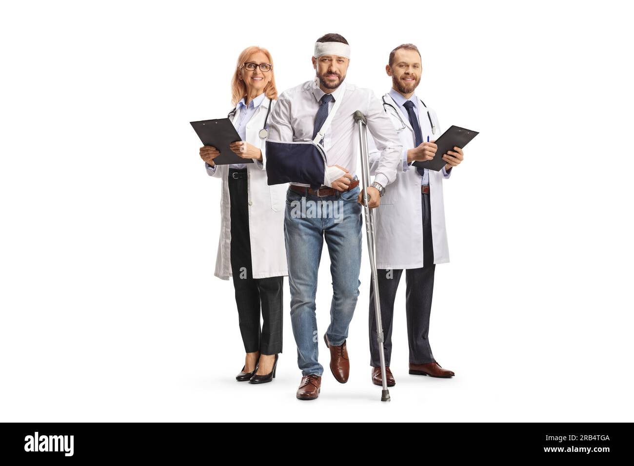 Ärzteteam und ein Mann mit einem verletzten Kopf und Arm, der mit Krücken auf weißem Hintergrund steht Stockfoto