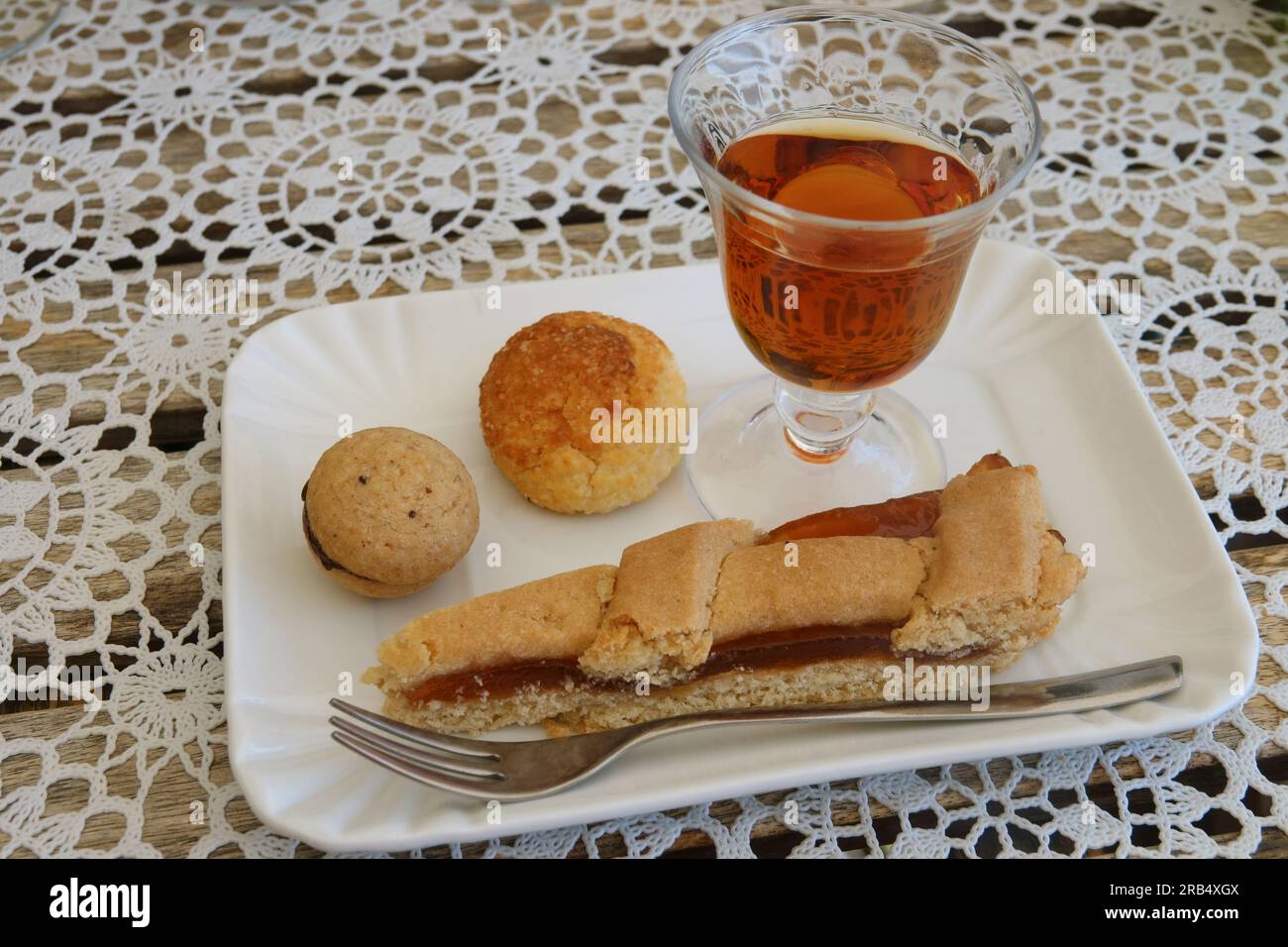 Ein Glas Sciacchetrà, ein Dessertwein aus der italienischen Region Cinque Terre, wird zusammen mit Backwaren gezeigt. Stockfoto