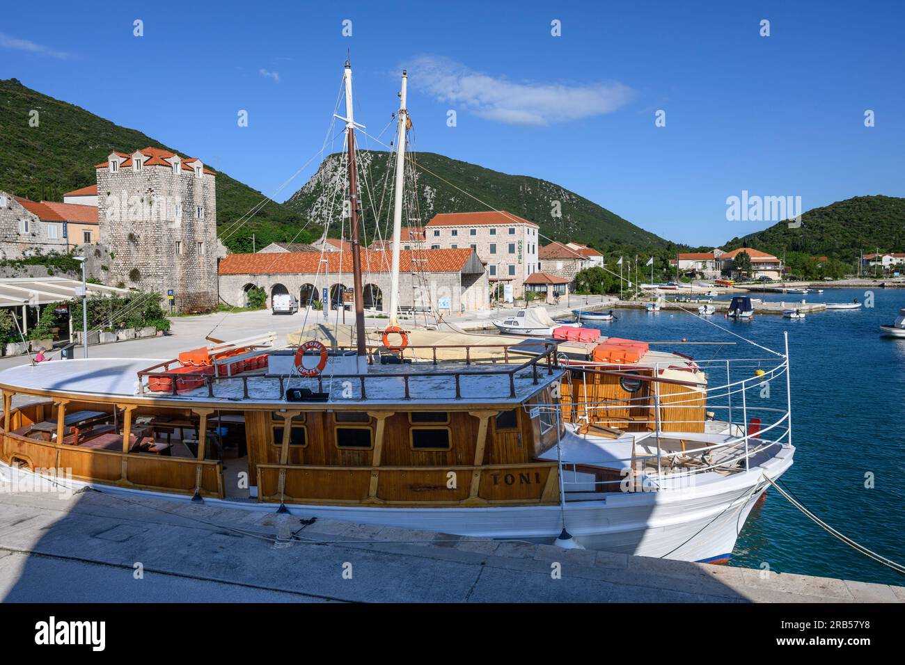 Blick auf das Wasser und den kleinen Hafen in Mali Ston mit den Hügeln der Peljesac-Halbinsel im Hintergrund. Mali Ston, Peljesac-Halbinsel Stockfoto