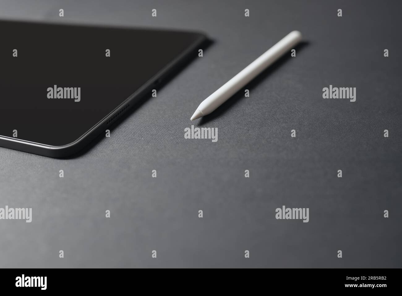 Nahaufnahme einer Tablette und eines Bleistifts auf grauem Hintergrund Stockfoto