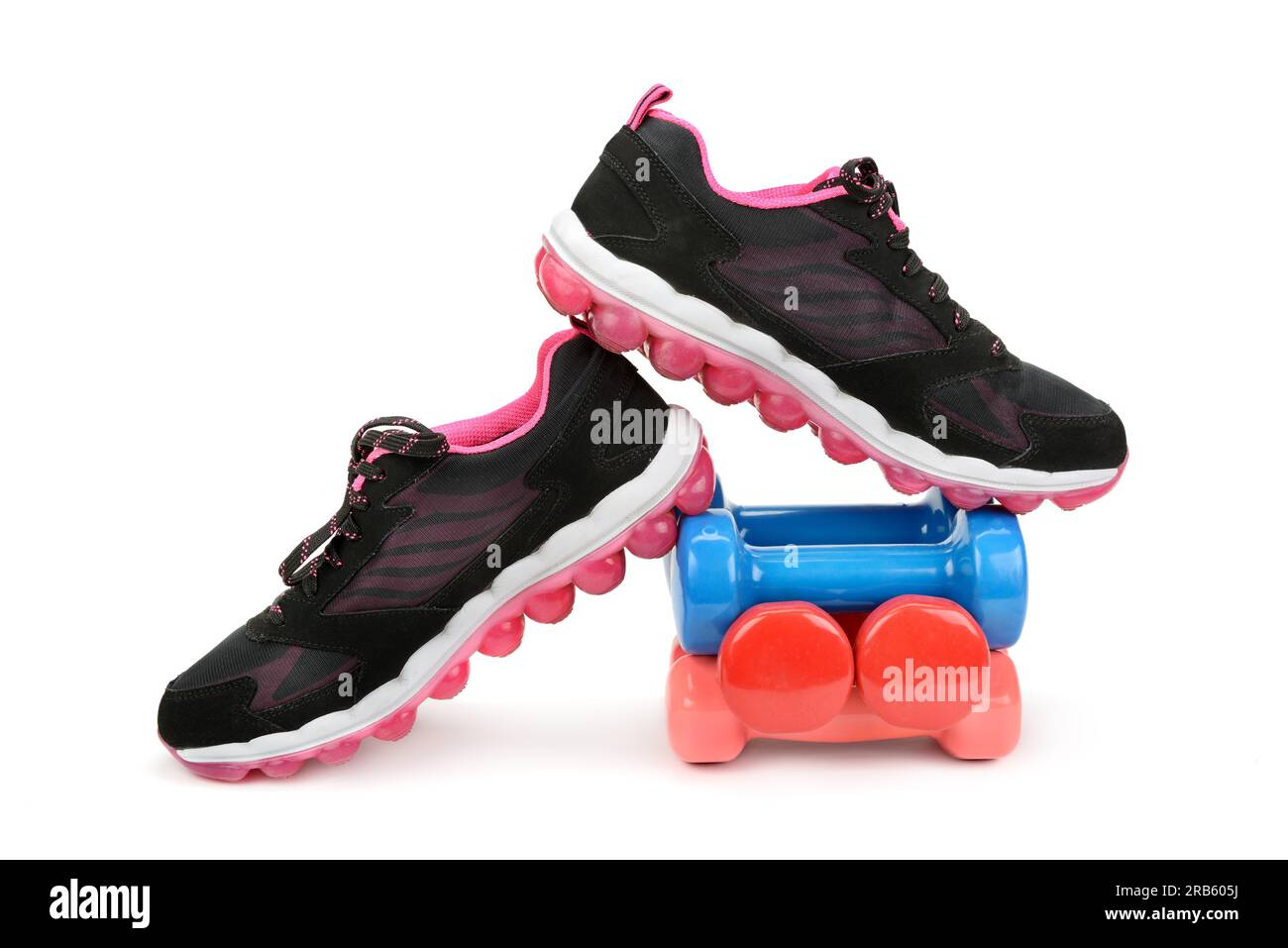 Paar Turnschuhe und Kurzhanteln isoliert auf weißem Hintergrund Stockfoto