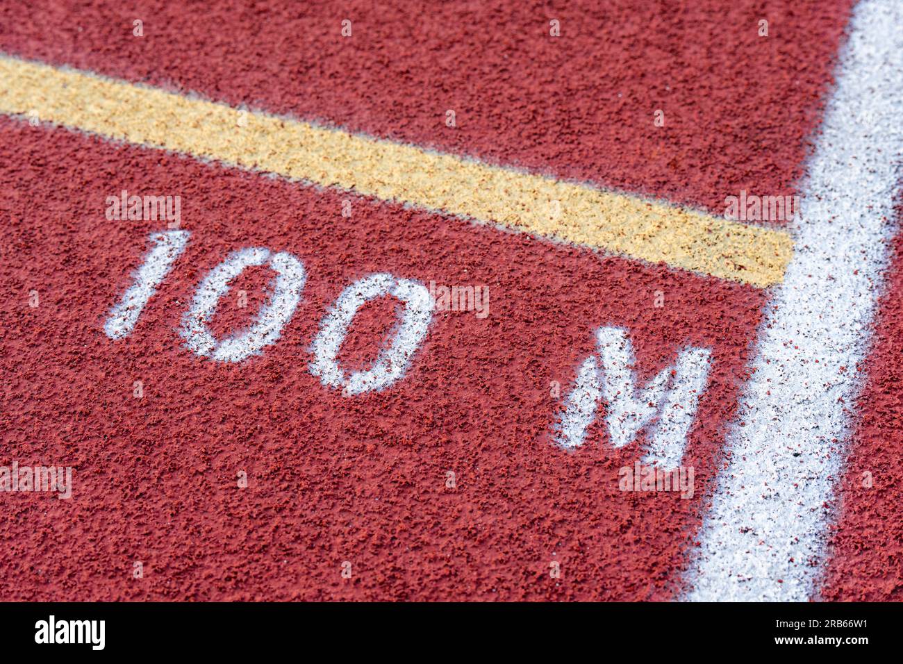 Nahaufnahme der neuen roten Laufstrecke mit 100-m-Text Stockfoto
