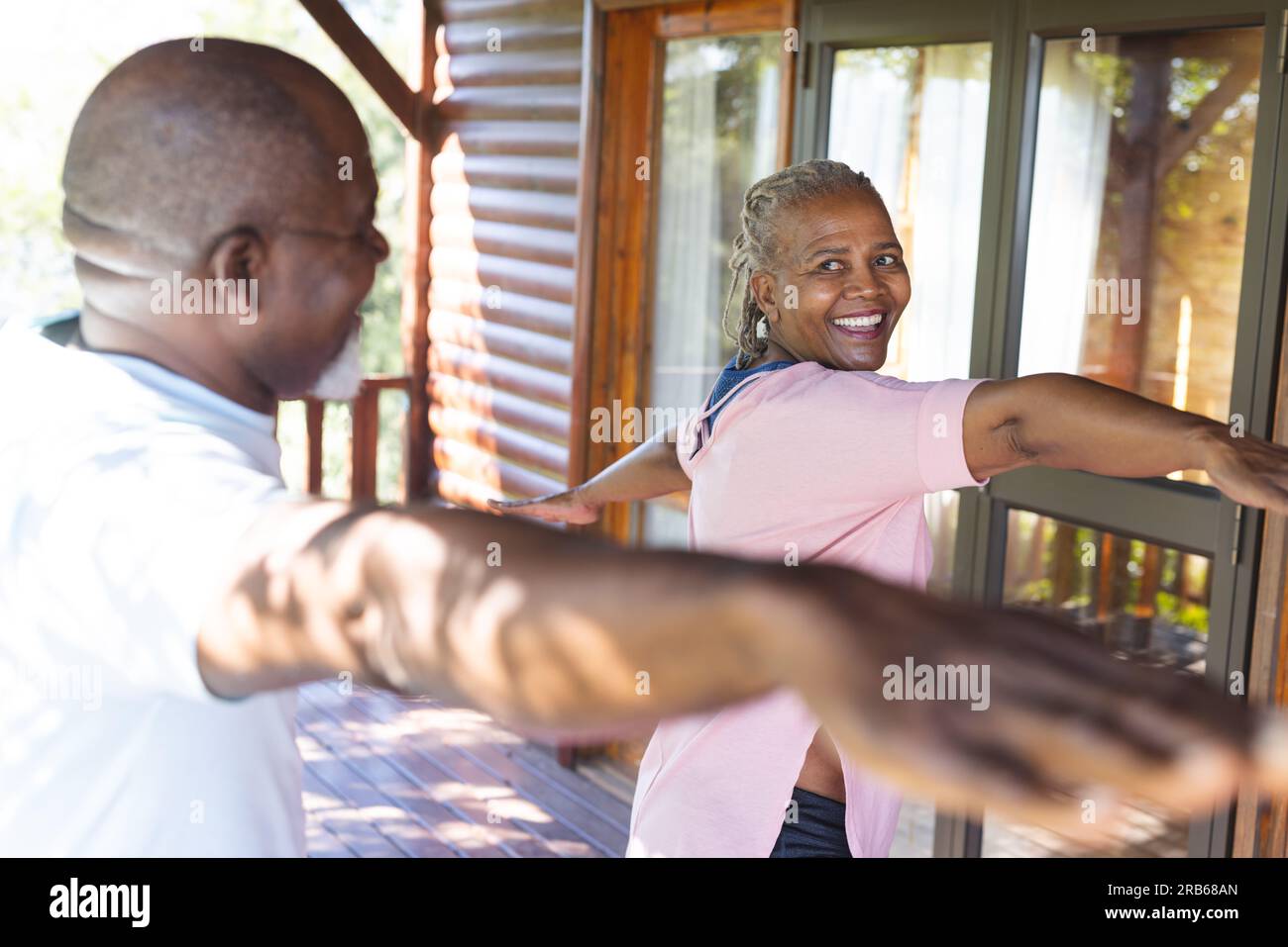 Glückliches Senior-afroamerikanisches Paar, das Yoga auf der Terrasse praktiziert. Seniorenleben, Entspannung, Ruhestand, gesundes Leben, Fitness, Bewegung und Wohlbefinden Stockfoto