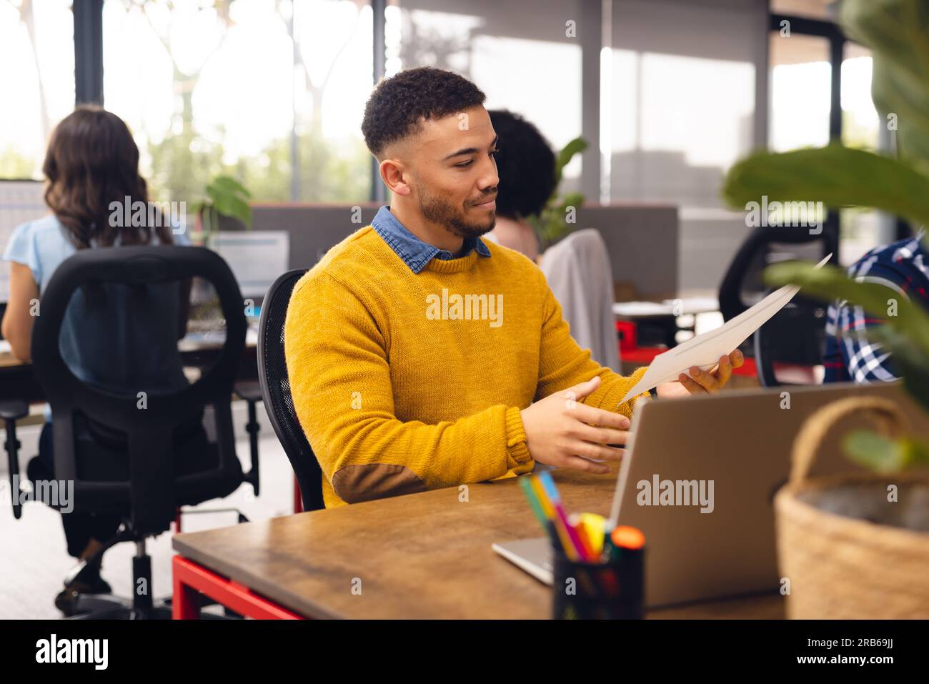 Verschiedene Geschäftsleute, die an Schreibtischen sitzen und Computer im Büro verwenden. Ungezwungene Geschäfte, Kommunikation und Arbeit, unverändert. Stockfoto