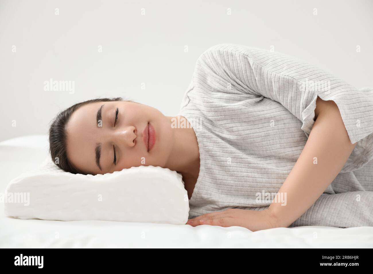 Frau, die drinnen auf einem Memory-Foam-Kissen schläft Stockfoto