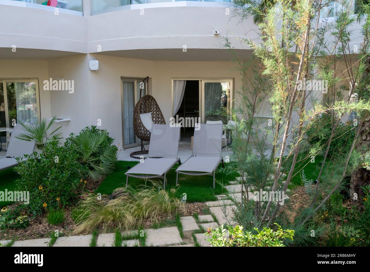 Entspannende Zeiten im Iberostar Hotel in Palma de Mallorca. Wunderschöner Erholungsraum für zwei Personen mit vielen Grünpflanzen, zwei Liegestühlen. Stockfoto