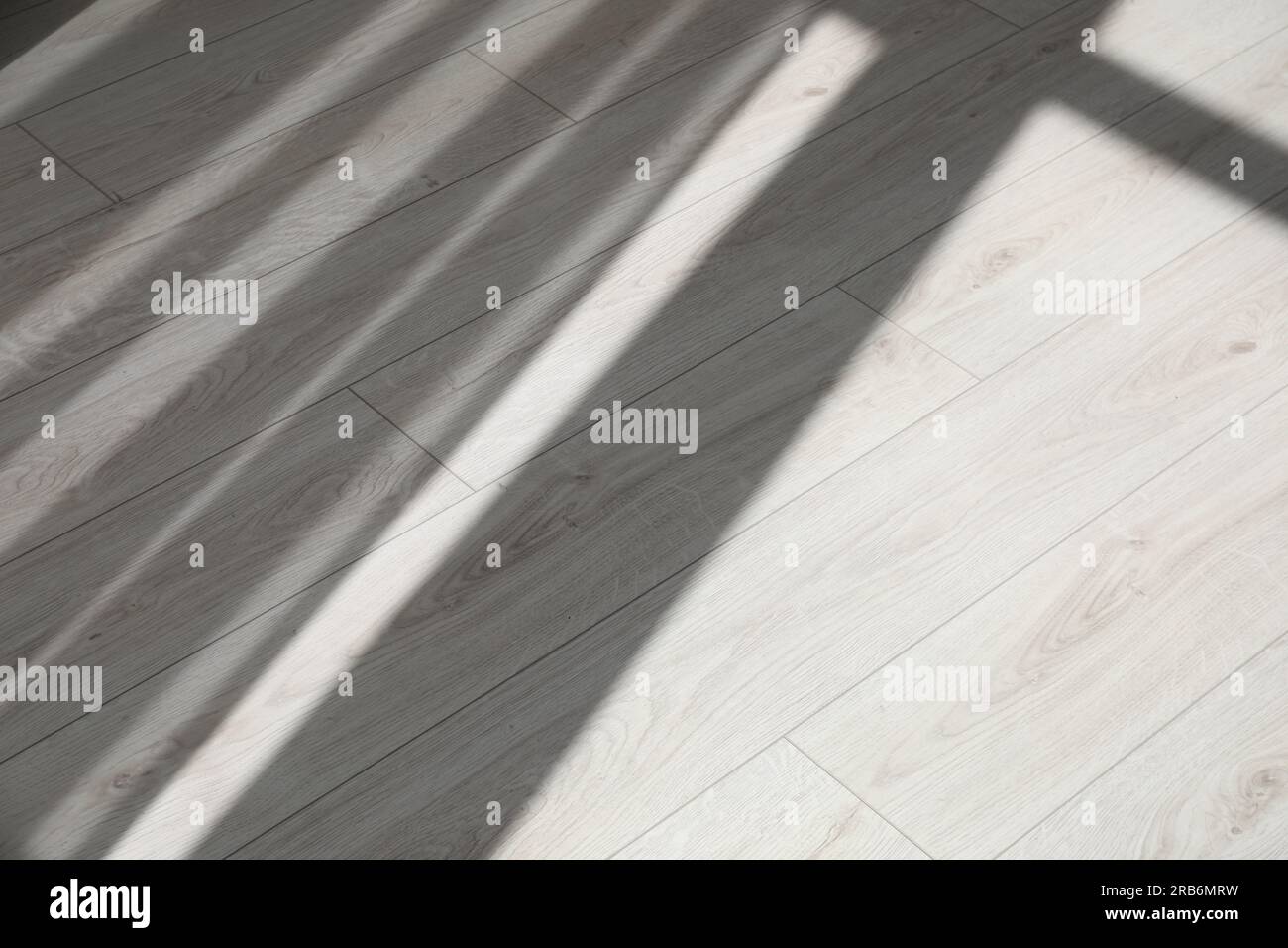 Schatten vom Fenster und Vorhänge auf weißem Laminatboden Stockfoto