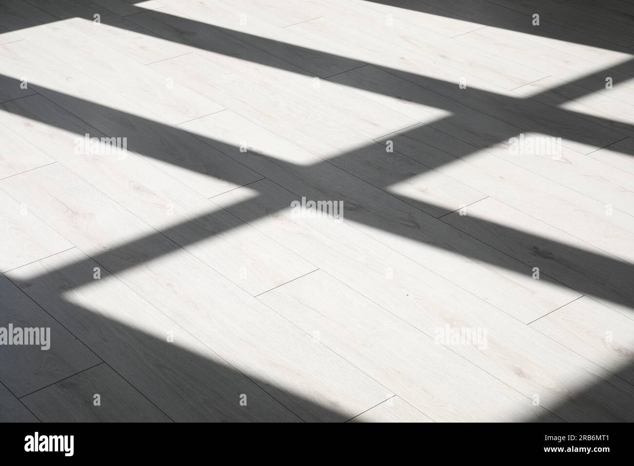 Schatten aus dem Fenster auf weißem Laminatboden Stockfoto