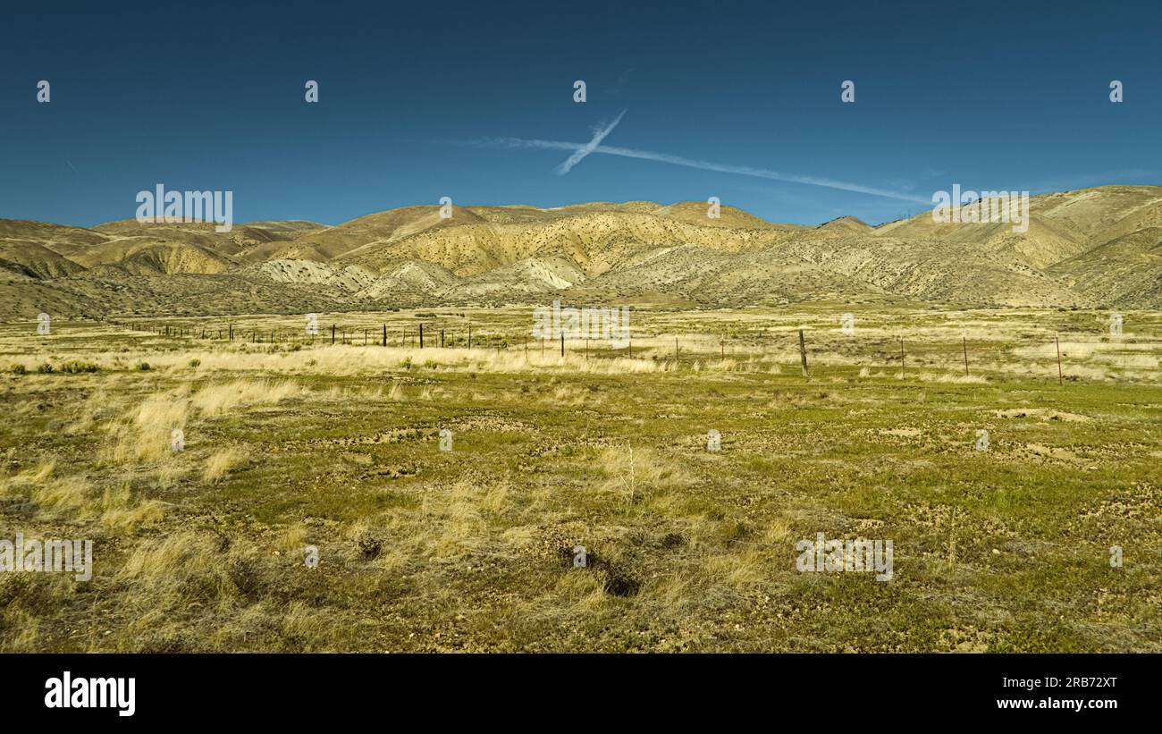 Ein Kreuz wie Wolken über dem Wüstenfeld und den Hügeln in Carrizo Plain. Stockfoto