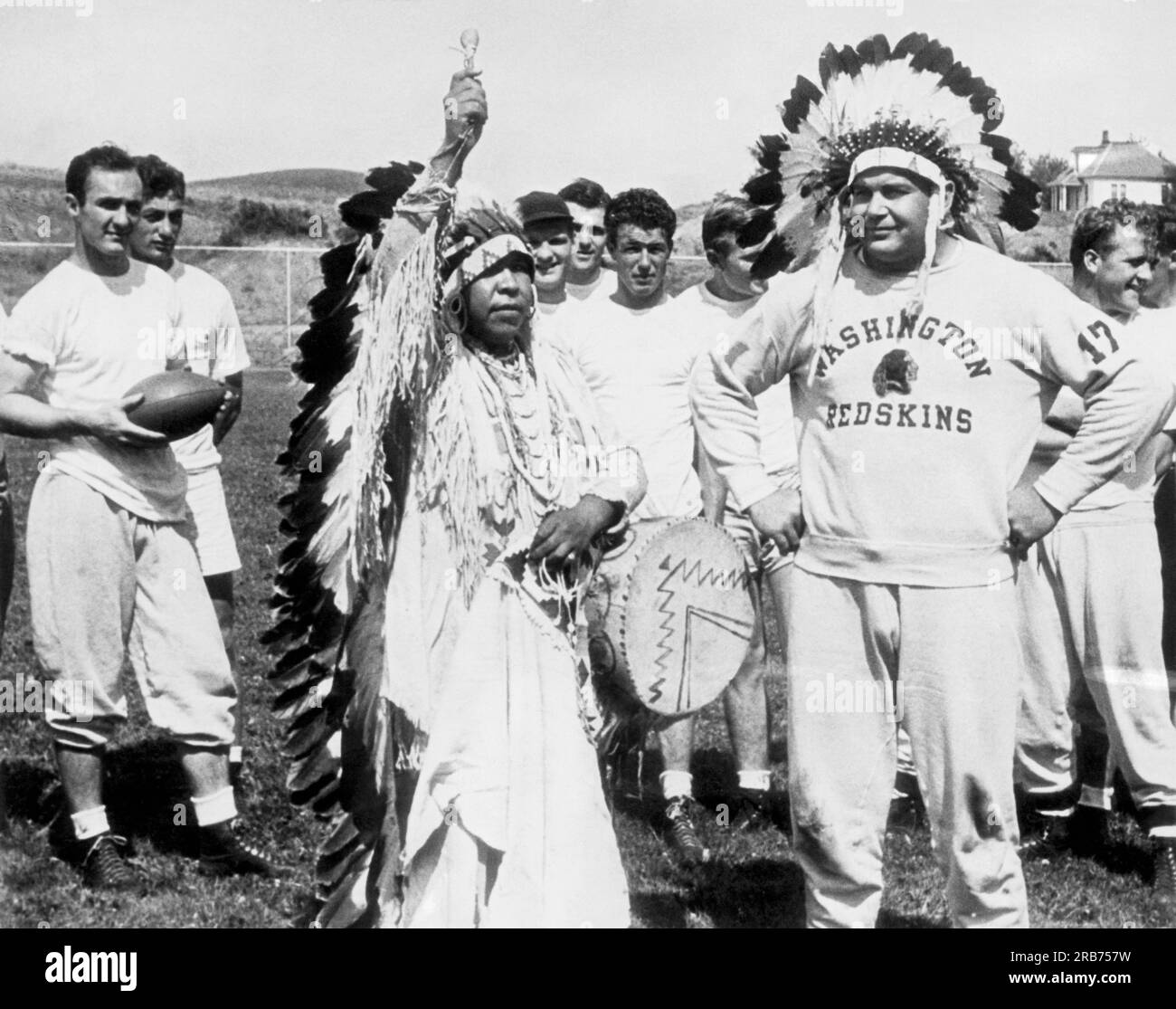 Cheney, Washington: 15. August 1939 Captain Turk Edwards von der Washington Redskins Profifußballmannschaft wird von Chief Black Spirit zum Ehrenmitglied des Spokane-Stammes mit dem Namen „Chief Red Feathers“ ernannt. Stockfoto