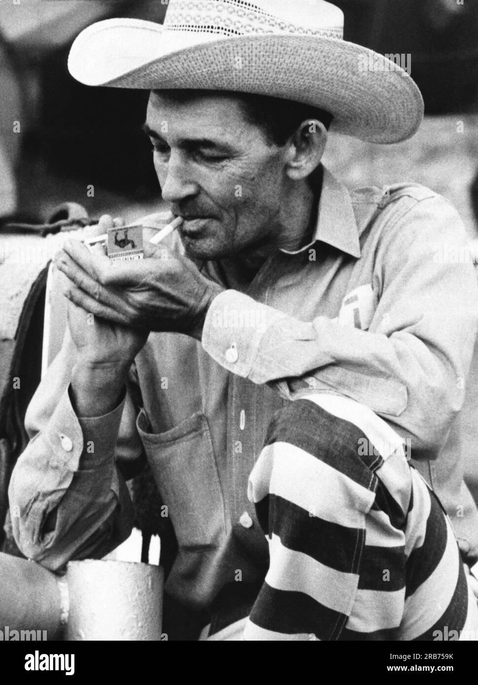 McAlester, Oklahoma: September. 1971 Ein Cowboy-Gefangener beim Gefängnis-Rodeo Zündet eine Kamelzigarette an. Er sagt, er war neun Mal im Gefängnis und wurde beschuldigt, nur wegen des Rodeos zurückgekommen zu sein. Stockfoto
