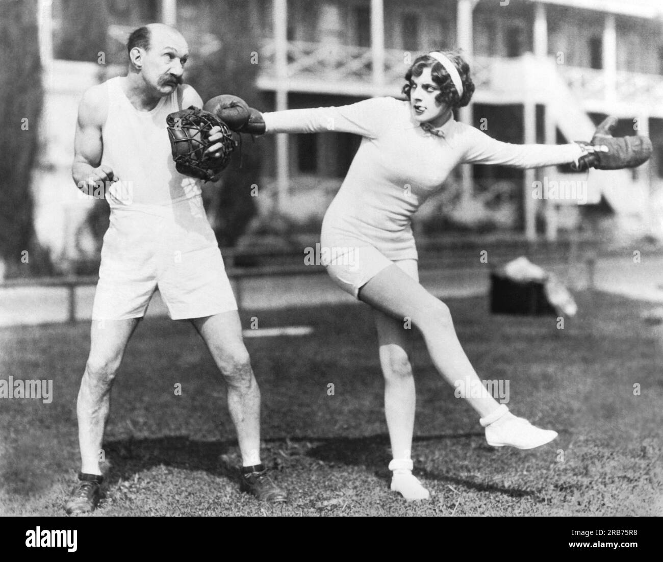 Hollywood, Kalifornien: c. 1929 Comedian Jimmy Finlayson fragt die Sportausrüstung von Schauspielerin Martha Sleeper, wenn er sie zu einem Baseballtraining vor der Saison einlädt Stockfoto