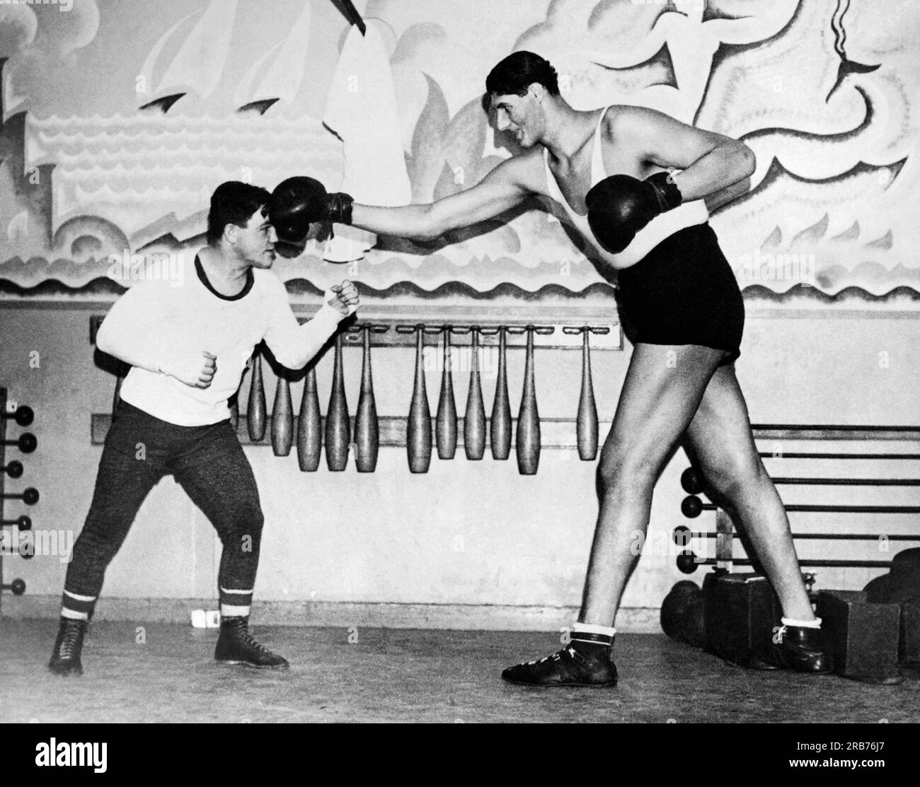 Paris, Frankreich: 18. Dezember 1935 Weltergewicht-Weltmeister kanadischer Lou Boruillard spielt mit dem rumänischen Schwergewichtsboxer Gogea Mitu, dem weltweit höchsten Boxer mit 7 m, 4 cm, ein wenig ungleich. Stockfoto