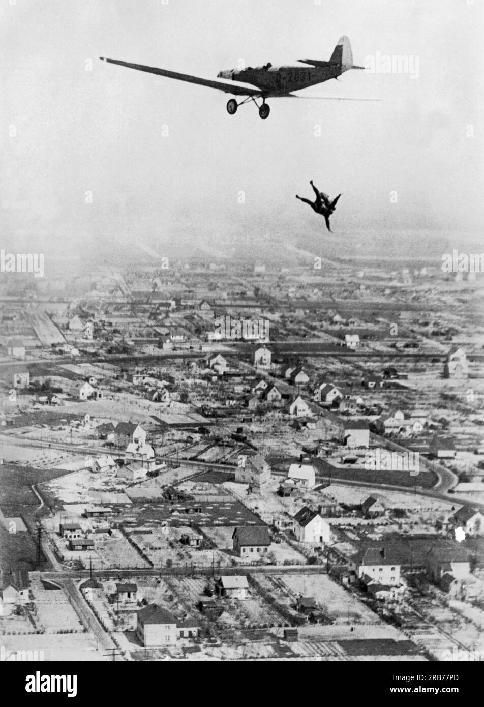 Deutschland: 24. Mai 1931 Willi Ruge ist bestrebt, die ersten Selbstporträts vom Fallschirm zu machen, wenn er aus einem Flugzeug springt. Hier taucht er Kopf voraus aus dem Flugzeug, um seinem Kollegen Herrn Boettcher den besten Effekt für sein Foto zu geben. Stockfoto