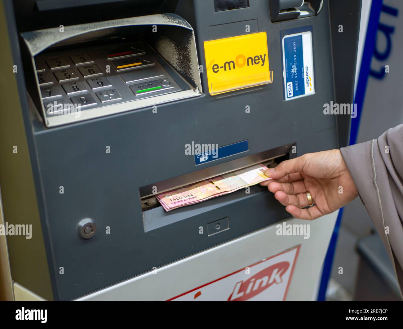 Yogyakarta-Indonesia, 1. Juli 2023: Eine Frau, die Geld vom Geldautomaten der Bank Mandiri in Yogyakarta, Indonesien, abhebt Stockfoto