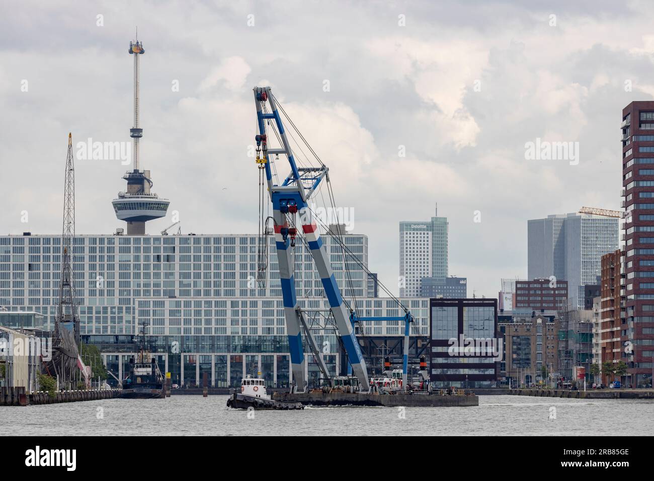 Rotterdam, Niederlande - 2021-07-07: Schwerlastkahn Matador 2 wird im Hafen von Rotterdam mit der Stadt im Hintergrund gezogen Stockfoto