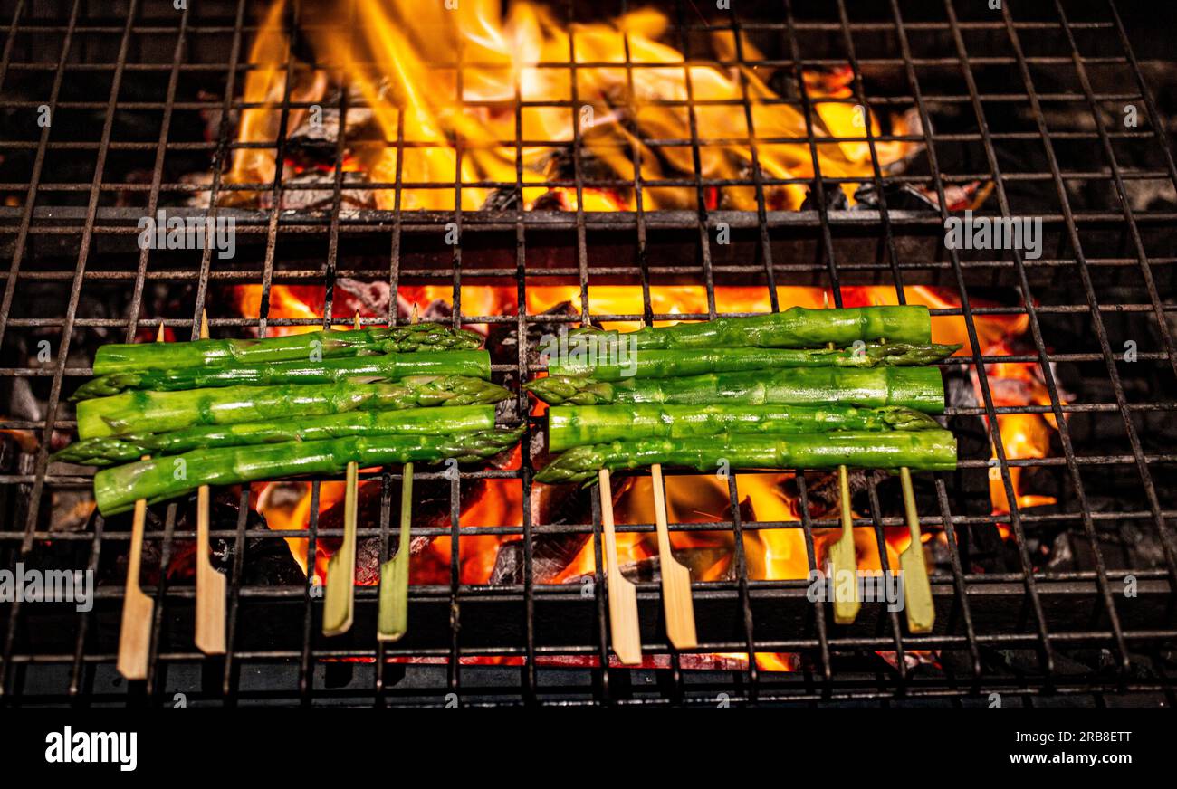 Gegrillter Spargel auf einem Grill im Freien mit offener Flamme Stockfoto