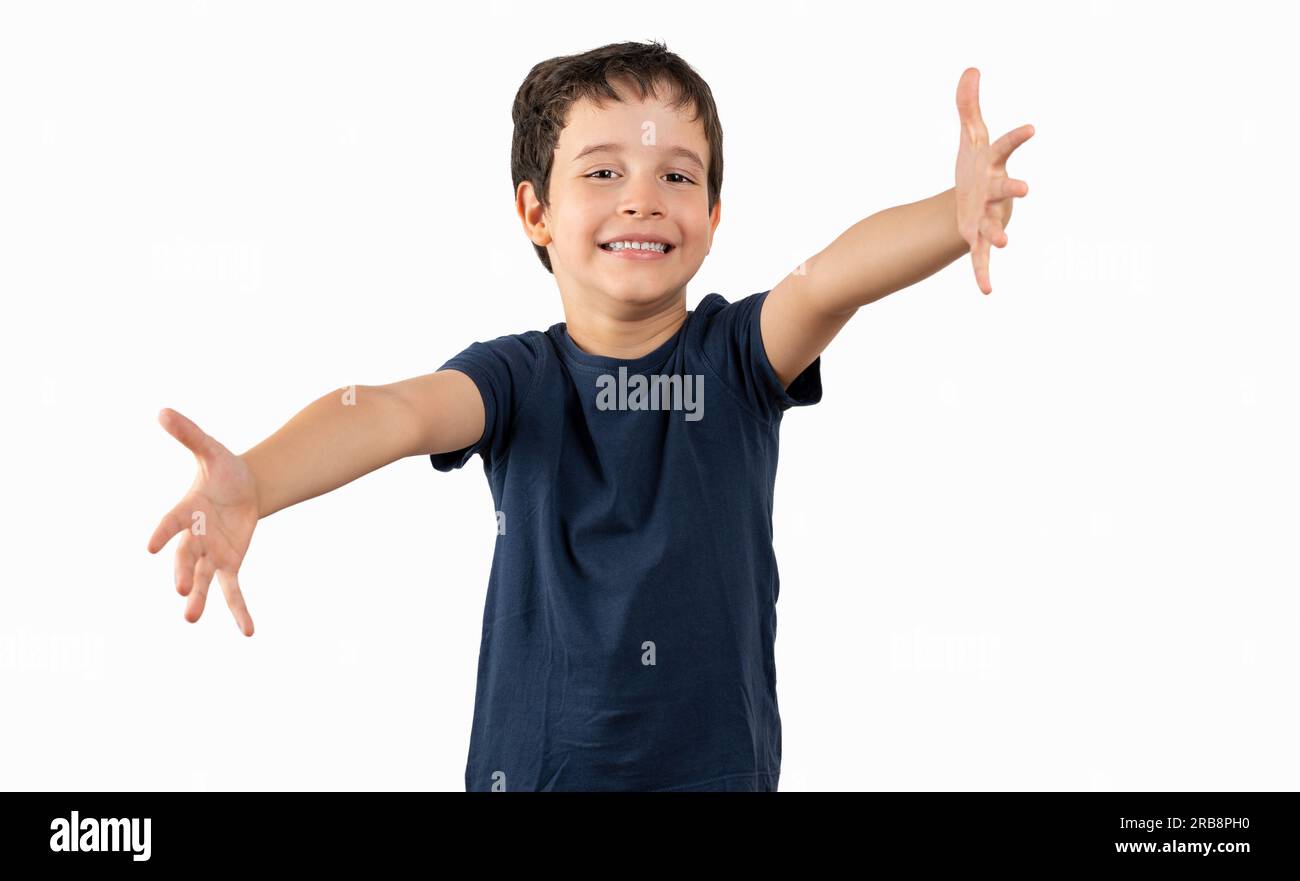 Ein Kind trägt ein Sommer-T-Shirt auf isoliertem weißem Hintergrund und sieht in die Kamera und lächelt mit offenen Armen zum Umarmen. Fröhlicher Ausdruck, der sich umarmt Stockfoto