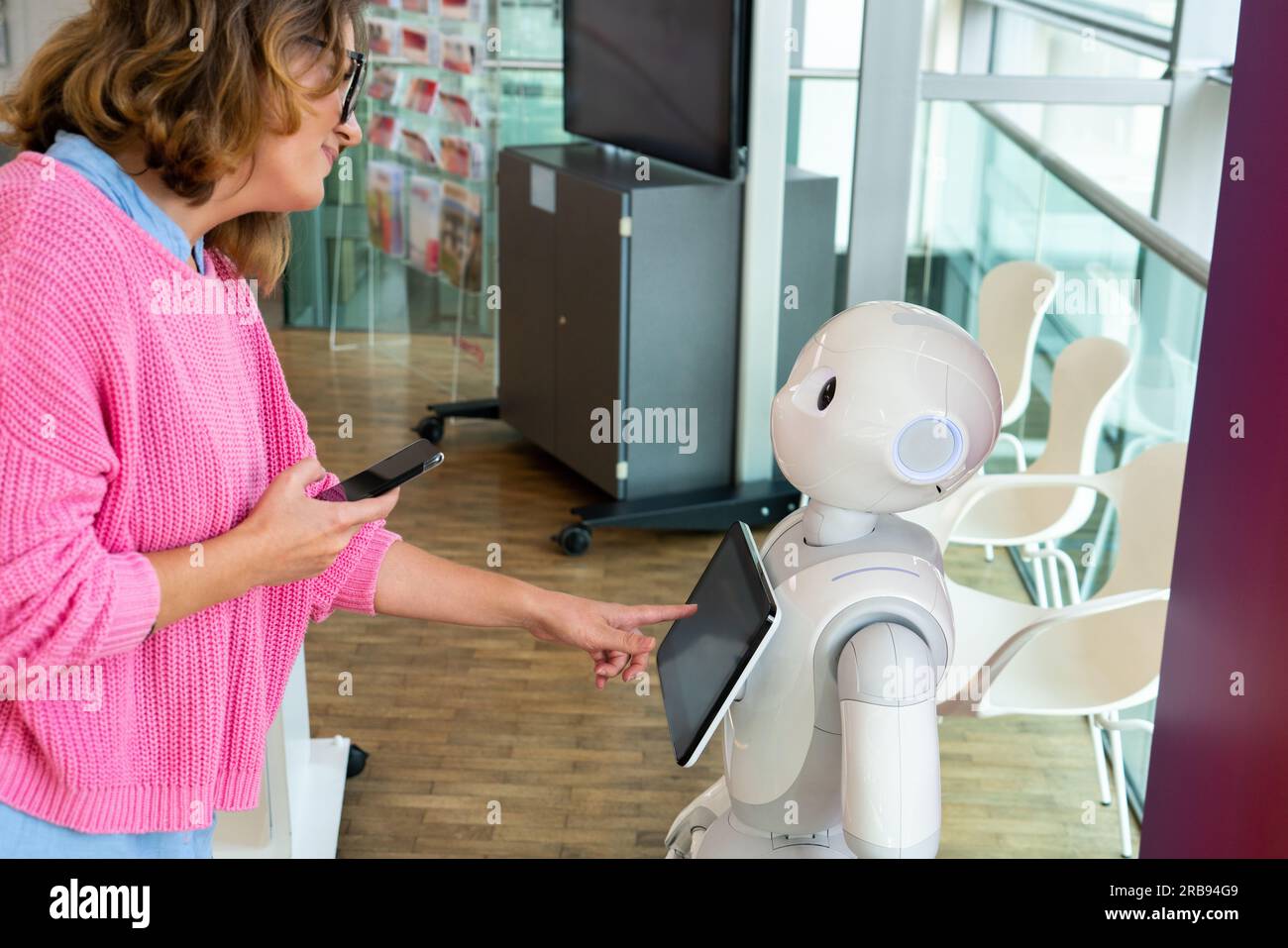 Eine Frau kommuniziert mit einem Roboterberater. Stockfoto