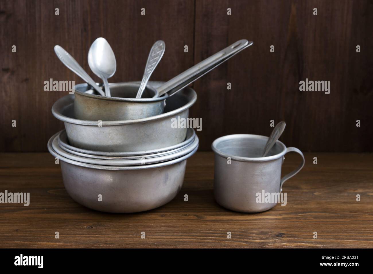 Verschiedene altmodische Küchenutensilien aus Aluminium auf Holzhintergrund Stockfoto
