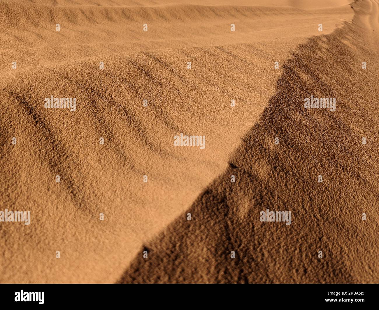 Orangefarbener und strukturierter Hintergrund. Wadi Rum Wüste, Jordanien, malerisches wunderschönes Panorama, Nahaufnahme des Restorange-Sands in der Wüste. Üppige Lava für Augenblicke Stockfoto