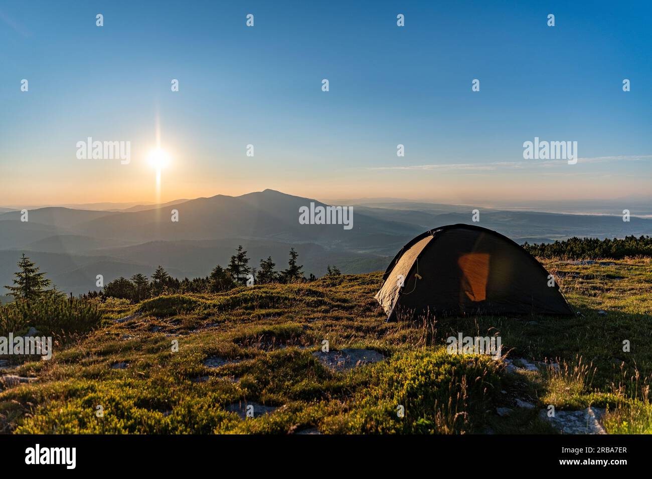 Zelt auf dem Gipfel in den Bergen bei Sonnenaufgang. Die Sonne geht über Babia Gora auf Stockfoto