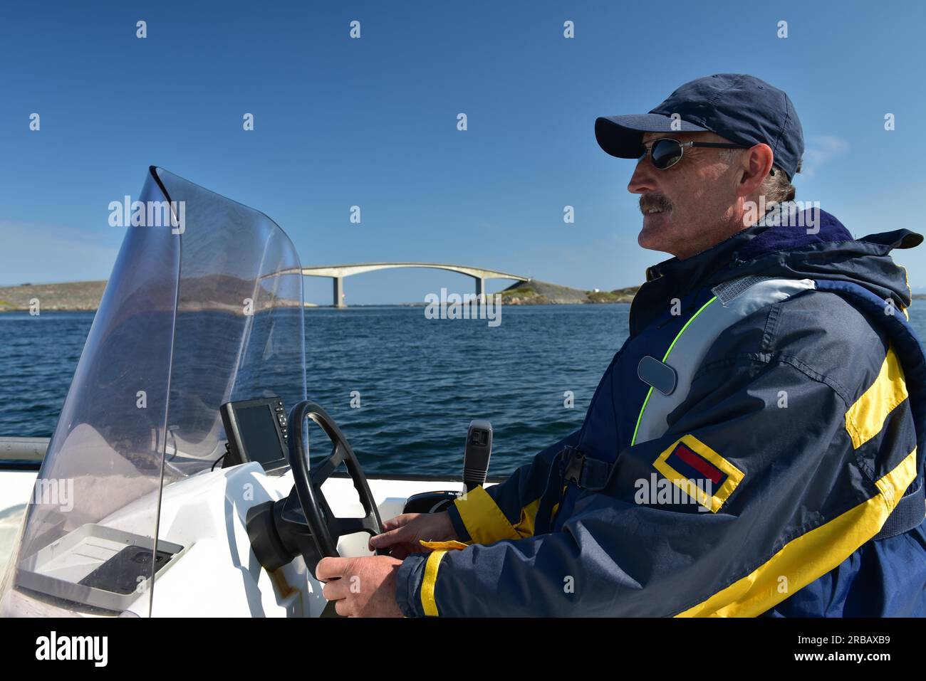 Mann, der Motorboot auf der Atlantikstraße in Norwegen fährt Stockfoto